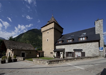 Innenhof des Parador de Arties mit Steinmauern, Holzbalkonen und Blumenschmuck in Katalonien