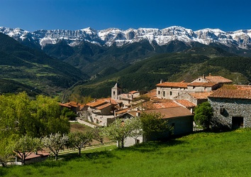 Blick auf die Pyrenäenkette mit einem romanischen Bergdorf in Katalonien – typische Landschaft entlang einer Paradores- und Selbstfahrerreise durch Nordspanien.